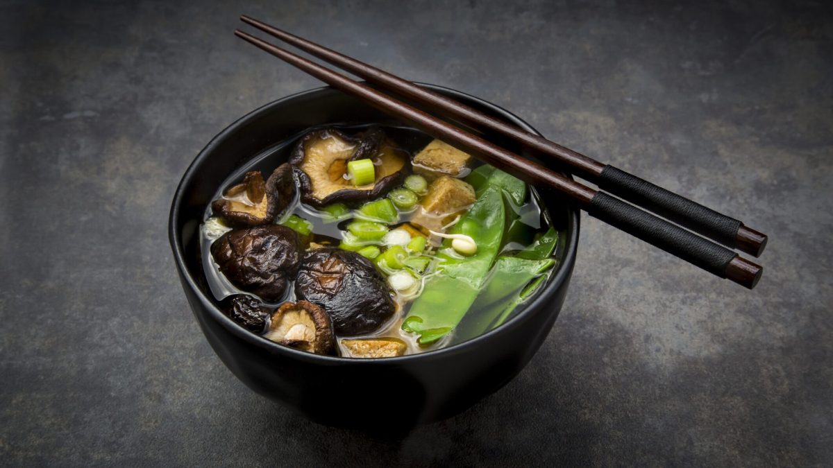 Kalorienarme Miso-Suppe mit Shiitake-Pilzen und Zuckerschoten in schwarzer Schüssel
