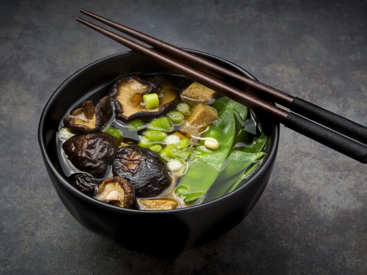 Kalorienarme Miso-Suppe mit Shiitake-Pilzen und Zuckerschoten in schwarzer Schüssel