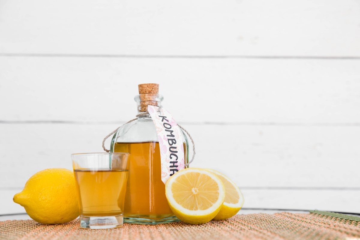 Dürfen Schwangere Kombucha trinken? Flasche und Glas mit Kombucha und Zitronen
