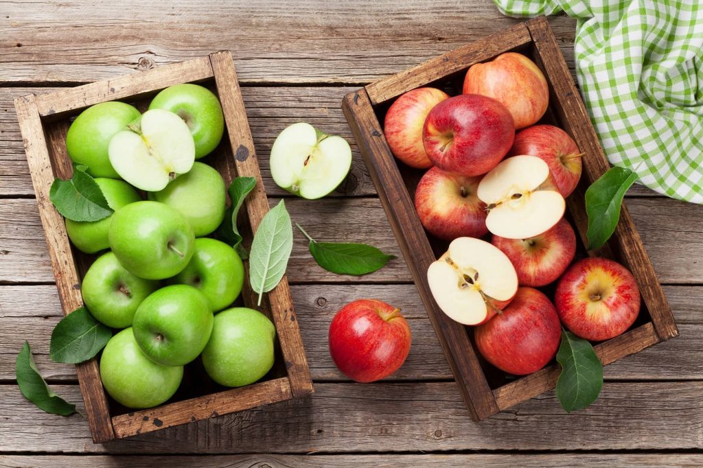 grüne und rote Äpfel liegen auf Holz