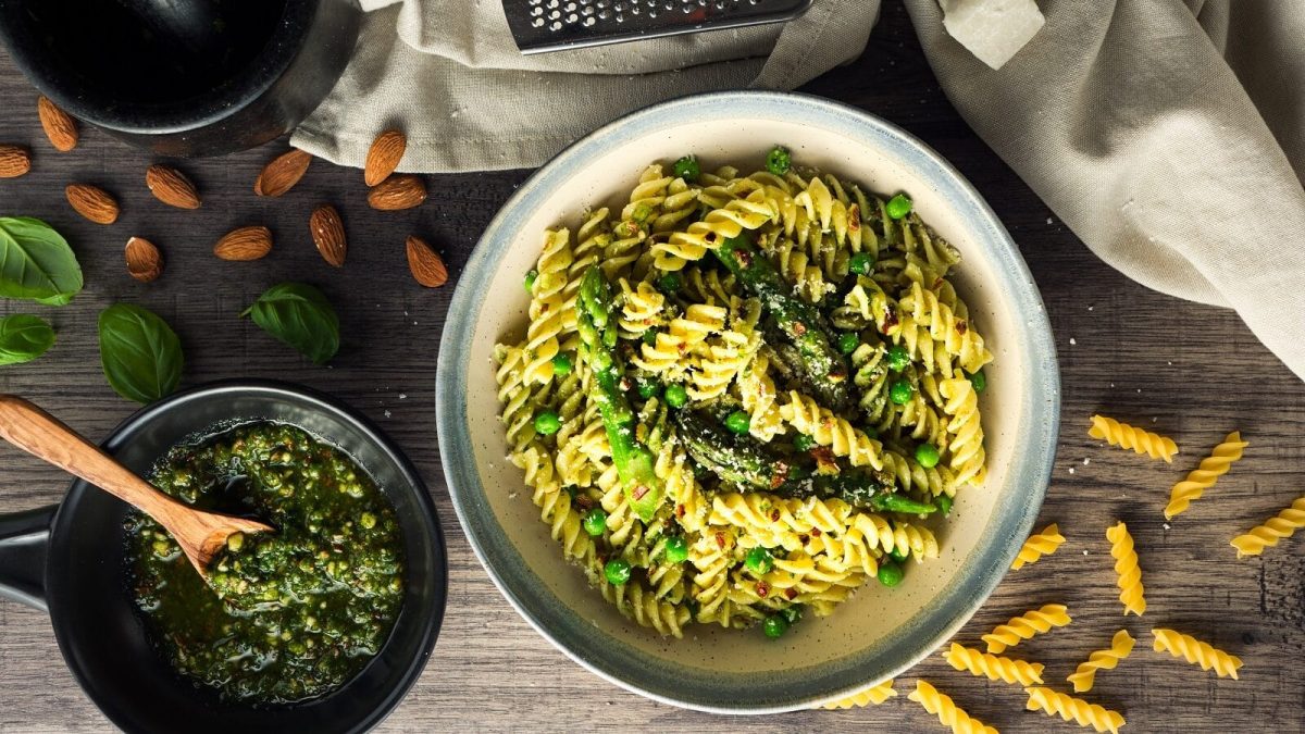 Spirelli-Pasta mit Pesto und grünem Spargel und Erbsen, mit geriebenem Parmesan garniert, von oben