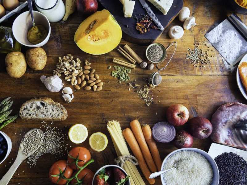 Ernährungsreport 2021: Draufsicht eines Tisches, auf den zahlreiche Lebensmittel, vor allem Obst und Gemüse, verteilt sind.