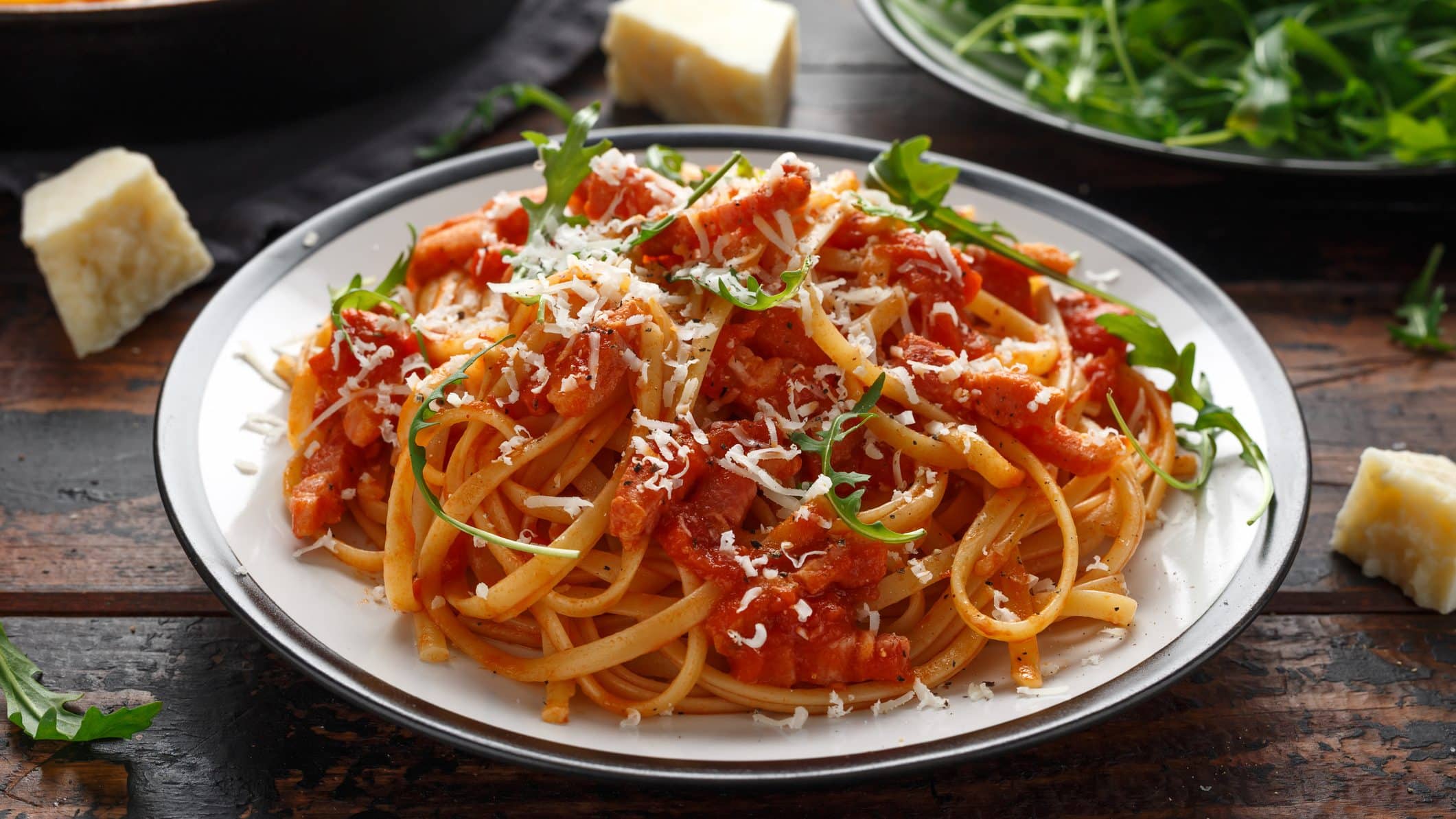 Auf einem großen Teller sind Spaghetti all amatriciana zu sehen. Es handelt sich um ein italienisches Traditionsgericht.