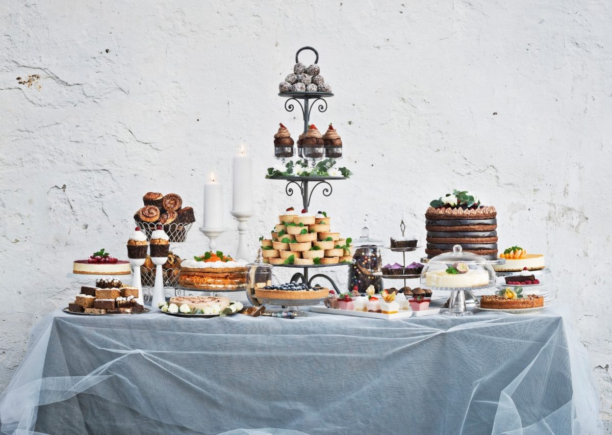 Ein Dessert-Buffet mit einer Vielzahl verschiedener Torten, Kuchen und Süßspeisen, aufgebaut auf einem Tisch.