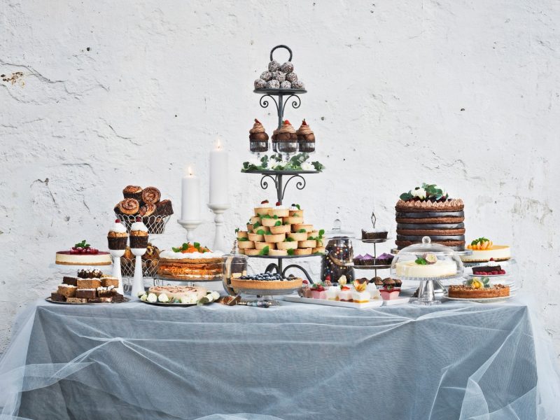 Ein Dessert-Buffet mit einer Vielzahl verschiedener Torten, Kuchen und Süßspeisen, aufgebaut auf einem Tisch.