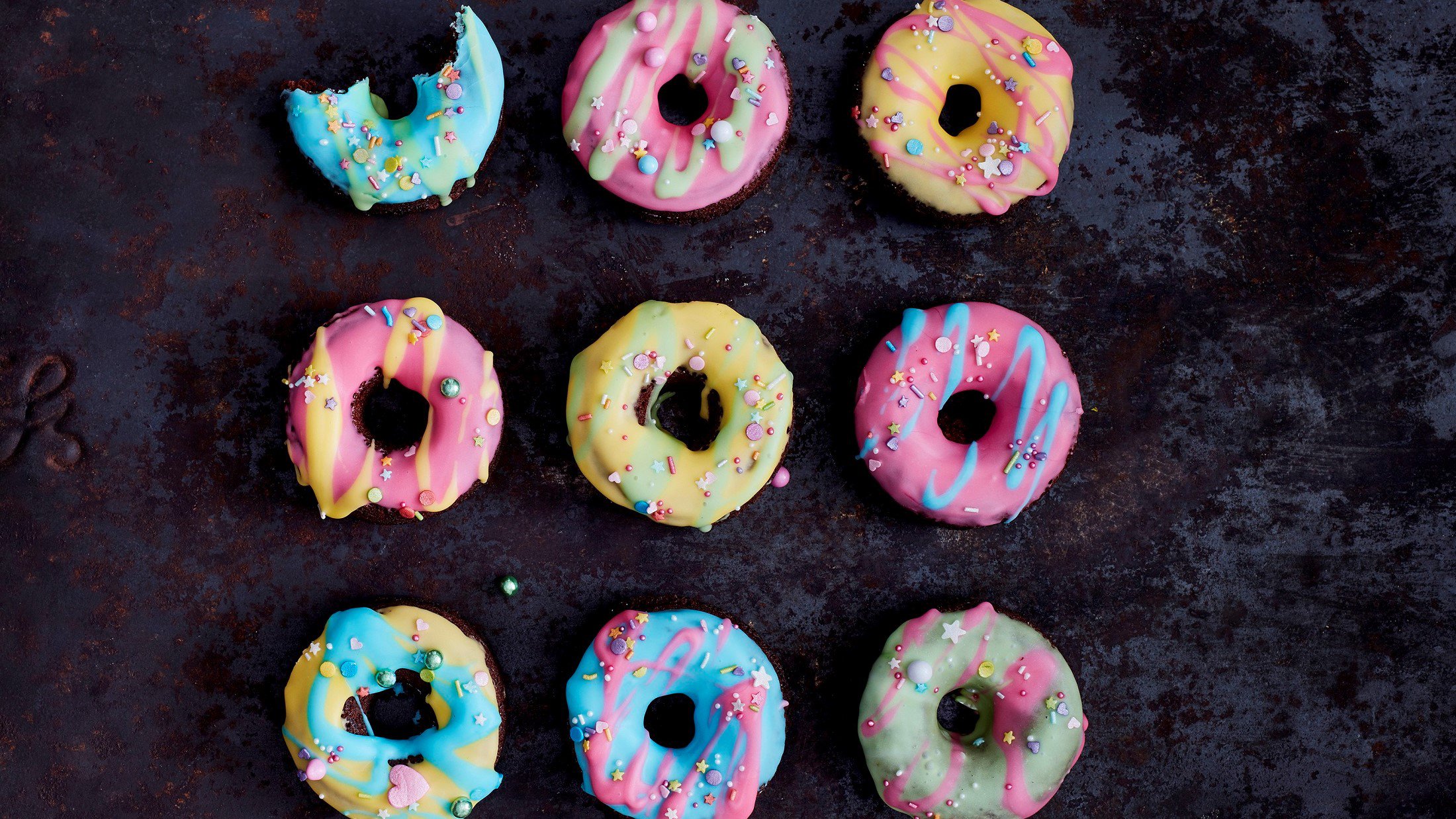 Bunte Donuts auf dunklem Hintergrund.