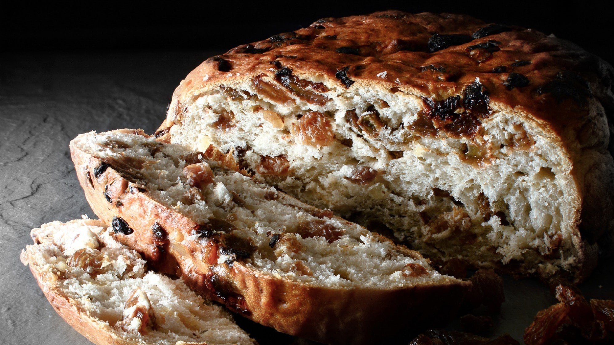 Es ist ein Leib Barmbrack Brot abgebildet. Man erkennt Rosinen und Sultaninen im Teig.