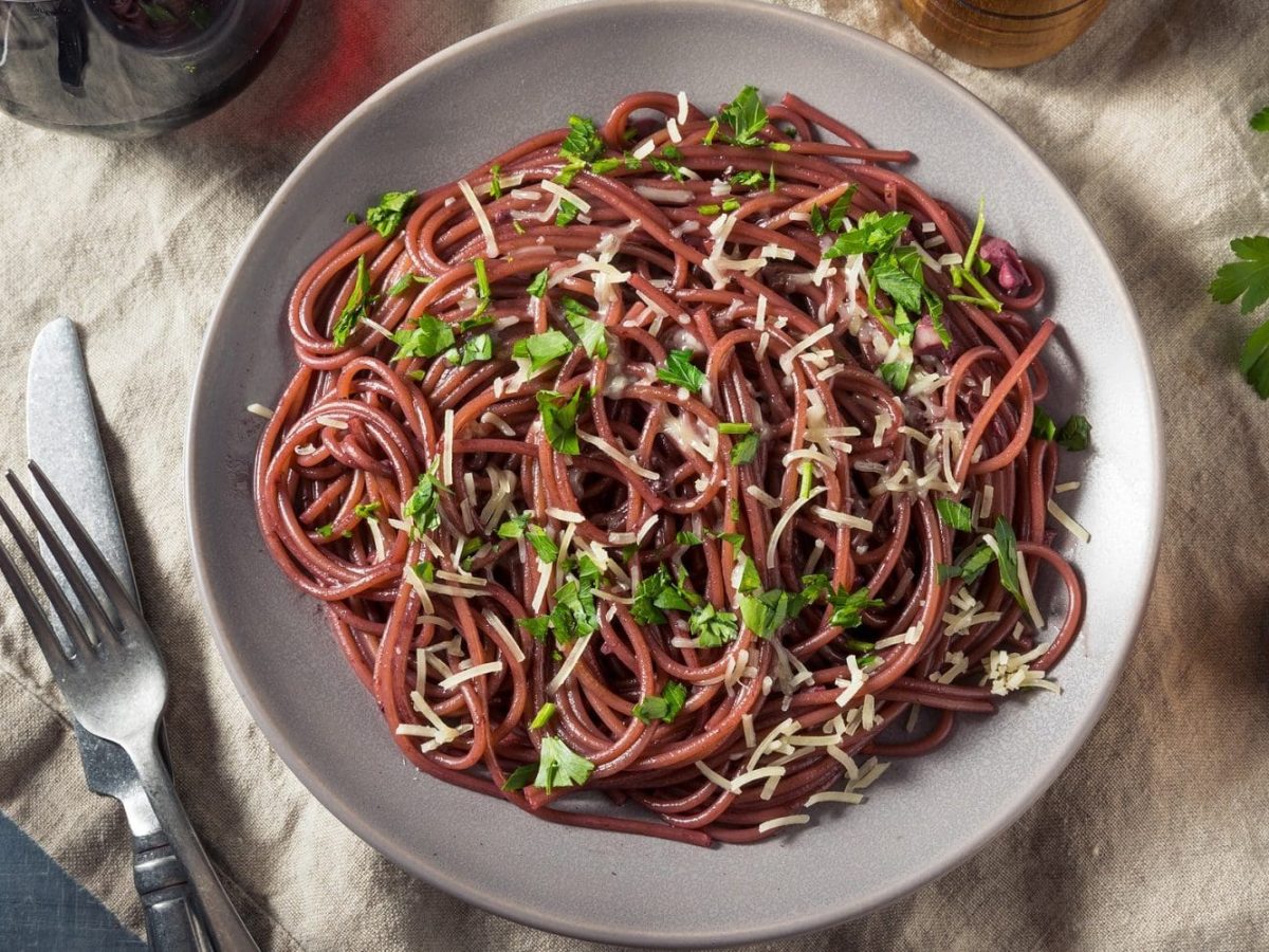 Aus der Vogelperspektive: Auf einem Tich steht ein Teller mit einer Rotwein-Pasta