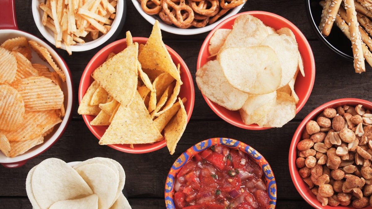Chips, Dips und Fritten: auf dem Tisch stehen unterschiedliche Snacks in kleinen Schälchen.