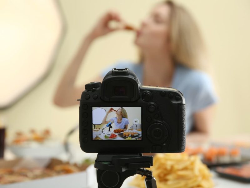 Blonde Frau beim ASMR Eating isst ein Stück Pizza und filmt sich dabei