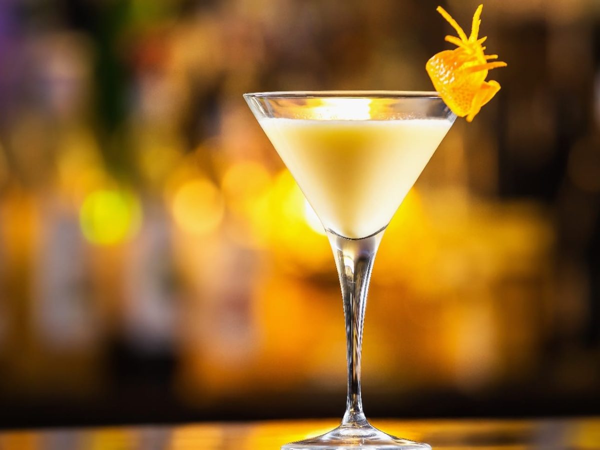 Ein Martini-Glas vor leuchtendem Hintergrund mit gelb-weißer Flüssigkeit.
