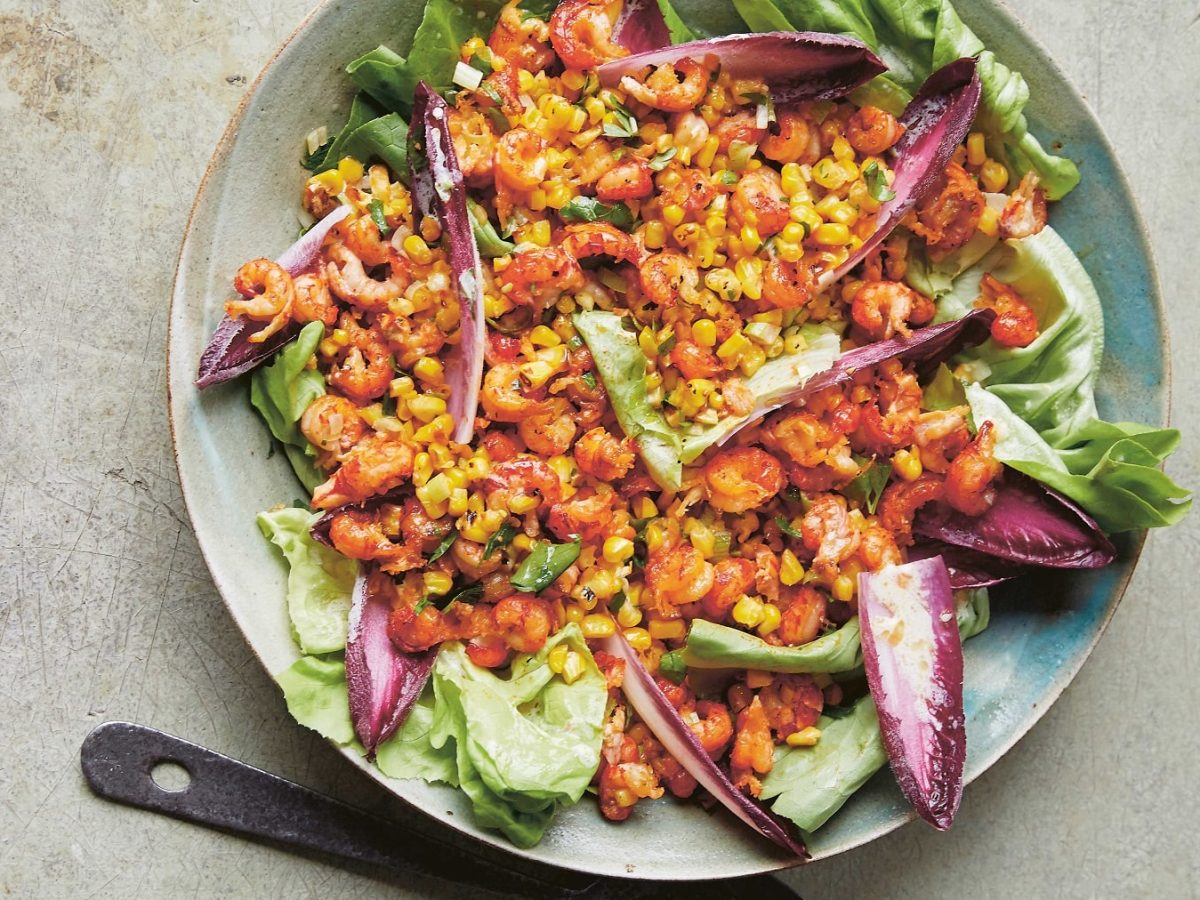 Ein Teller Krebs-Salat mit Mais und gemischtem Salat in der Draufsicht.