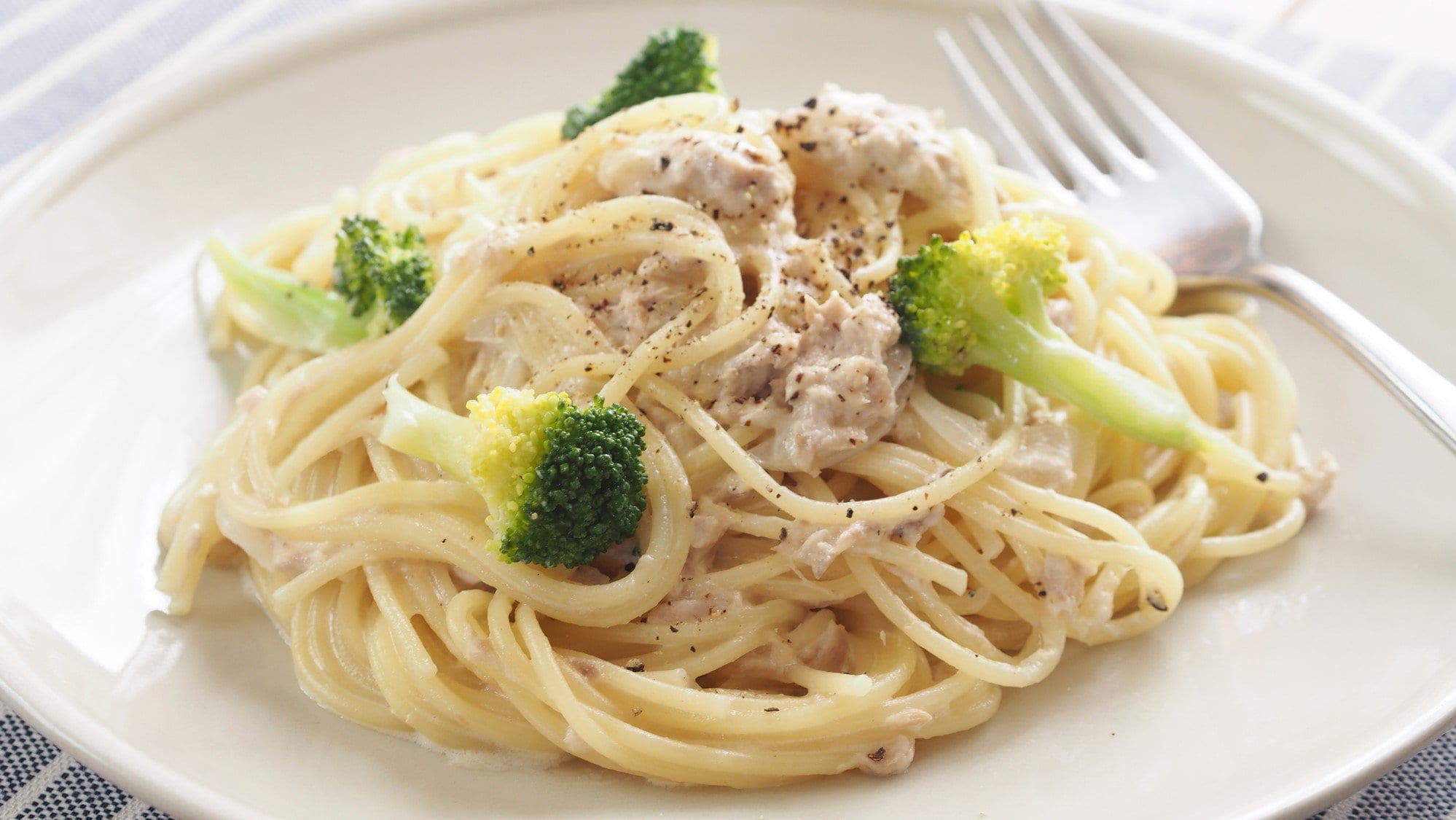 Spaghetti in Thunfischsauce mit Brokkoli auf weißem Teller