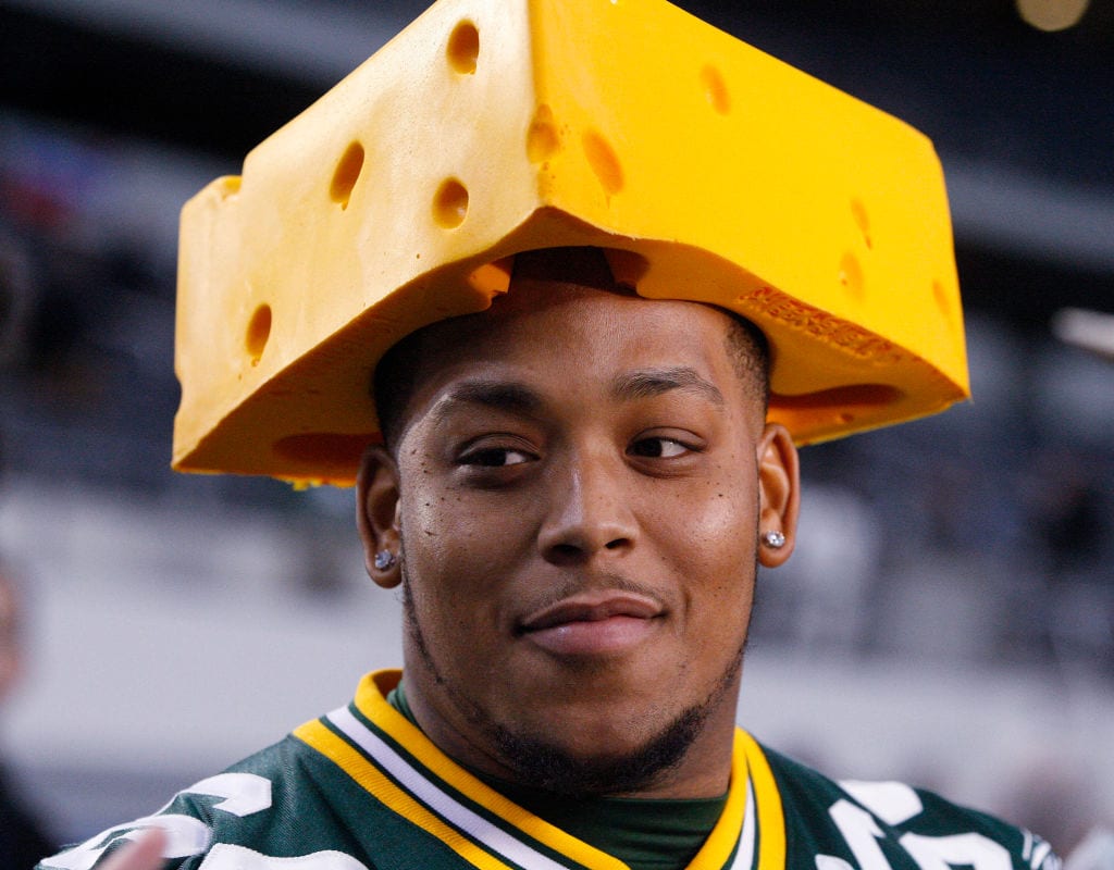 Ein Mann trägt einen Käse auf dem Kopf