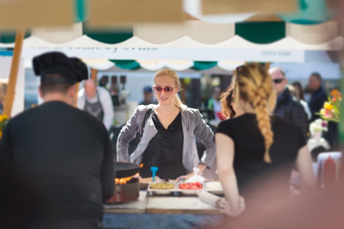 Greenfood Festival in Hamburg: Eine blonde Frau steht an einem Marktstand mit Essen.