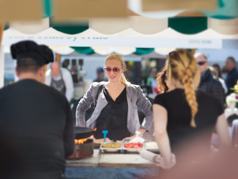 Greenfood Festival in Hamburg: Eine blonde Frau steht an einem Marktstand mit Essen.