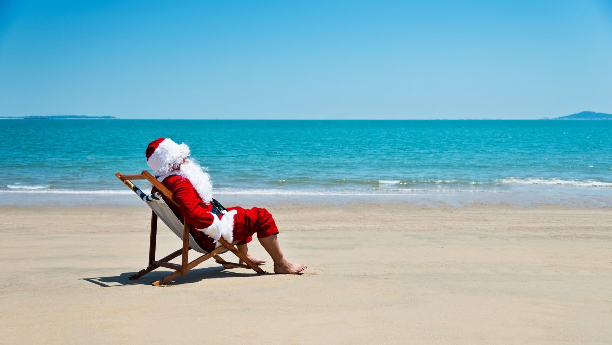 Sechs Monate bis Weihnachten: Ein Weihnachtsmann sitzt im Liegestuhl am Strand.