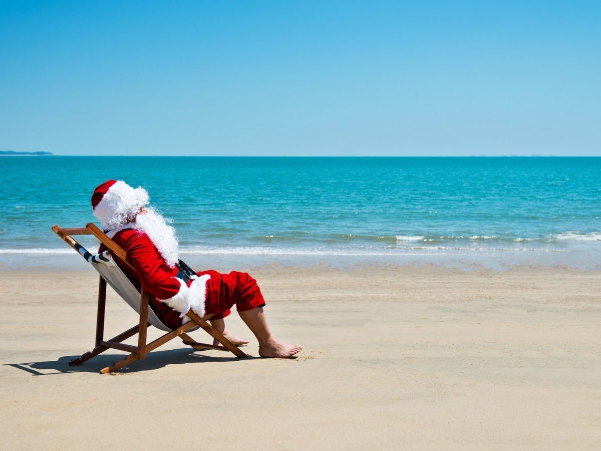Sechs Monate bis Weihnachten: Ein Weihnachtsmann sitzt im Liegestuhl am Strand.