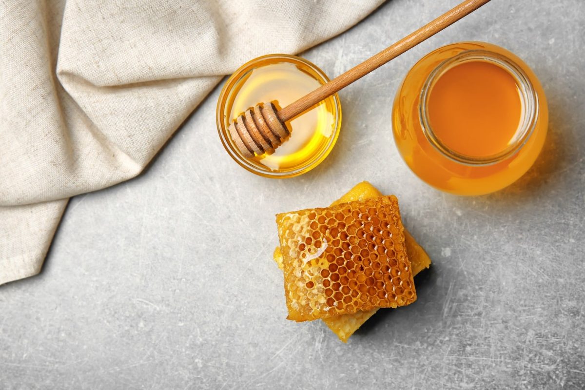 Ein Honigtopf mit Honiglöffel und kristallinem Honig