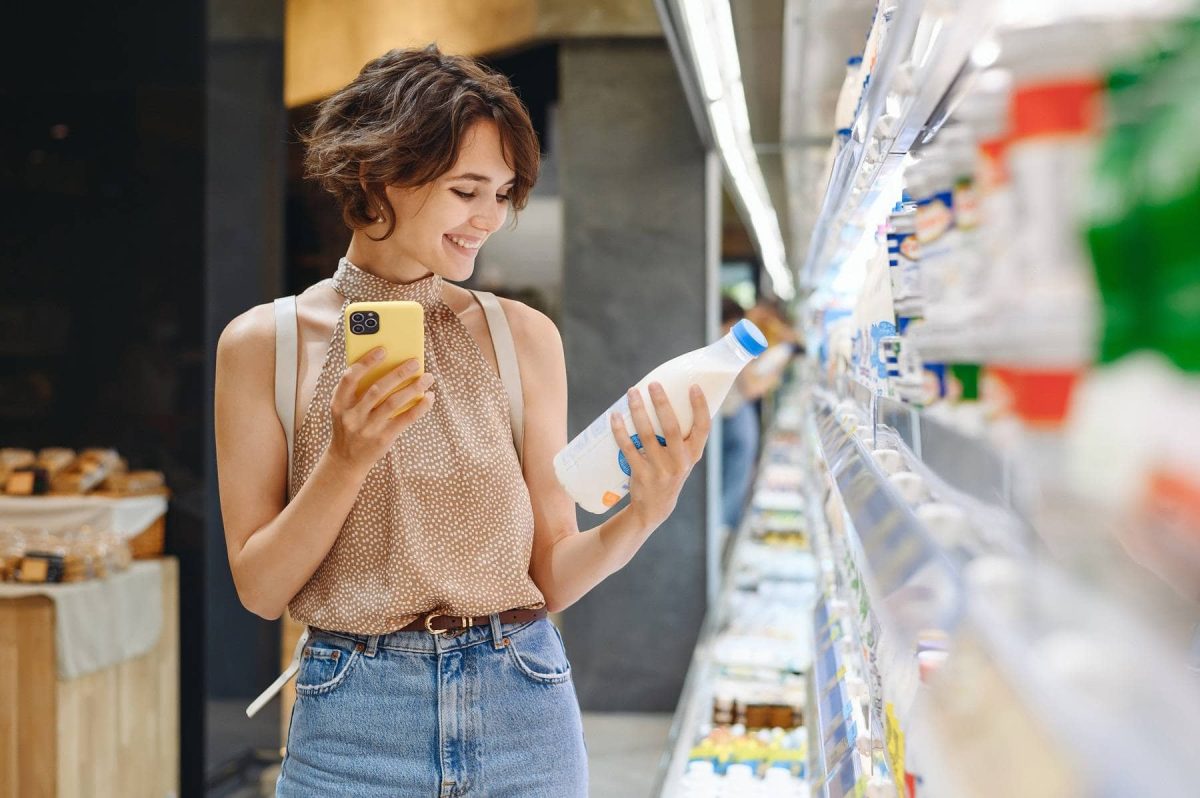 Eine Frau prüft im Supermarkt das Mindesthaltbarkeitsdatum eines Produktes.