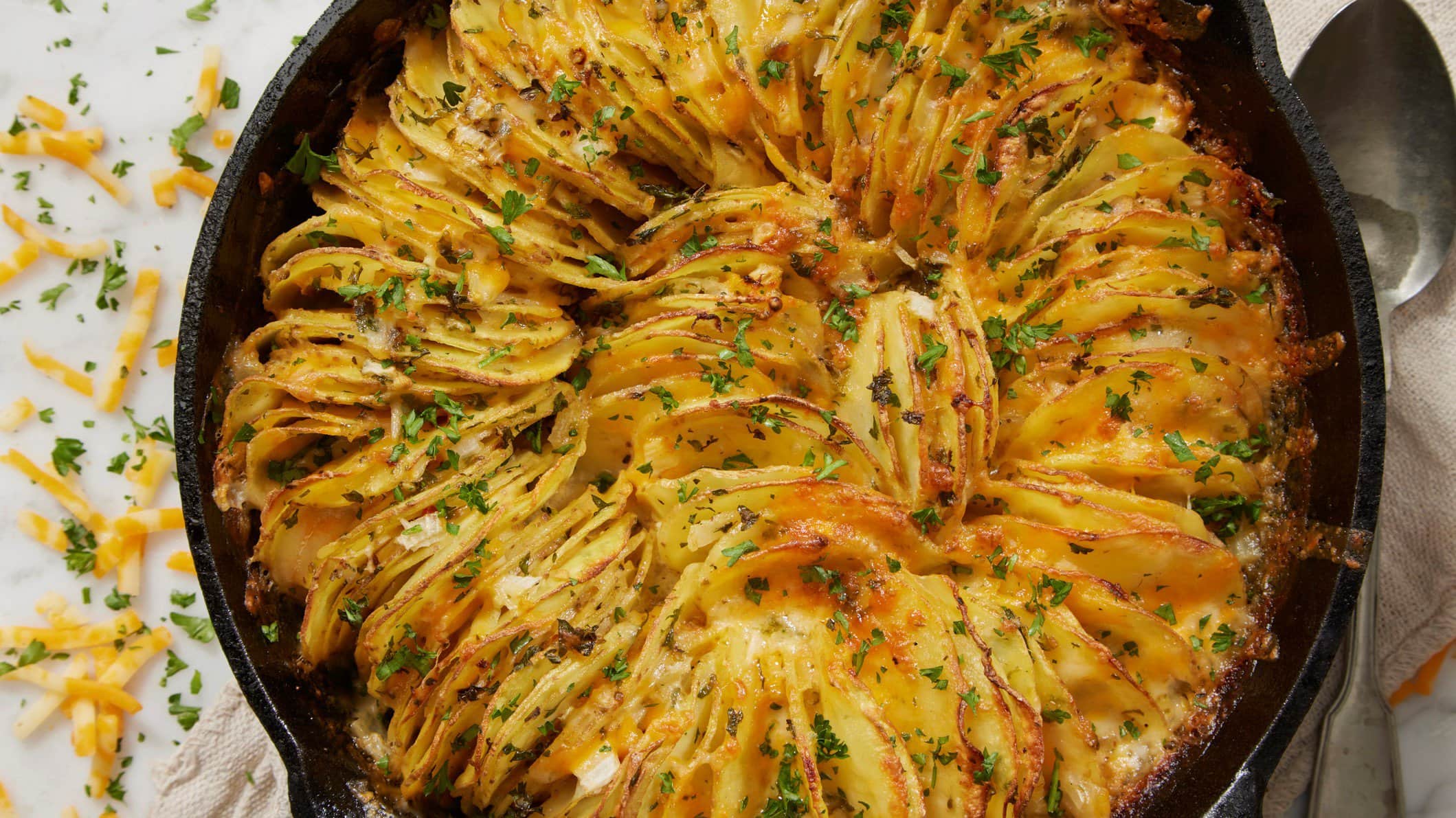 Mit Käse überbackene Kartoffelblätter in gusseiserner Pfanne.