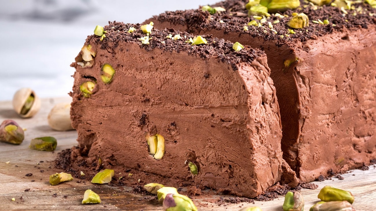 Frontalsicht: ein angeschnittenes Schokoladen-Parfait mit Pistazien.