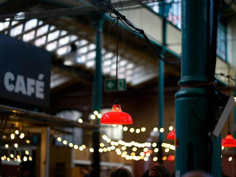 Christmas Klimbim: Eine Markthalle mit Lichterketten und einem "Café"-Schild.