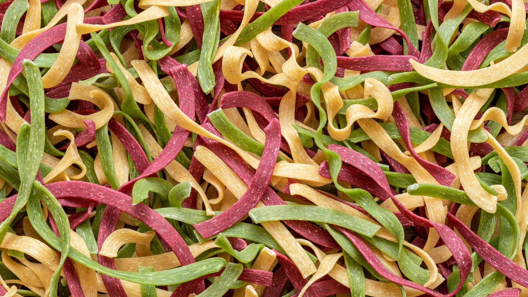 Bunte Pasta selbst machen - viele Tagliatelle in rot, gelb und grün.