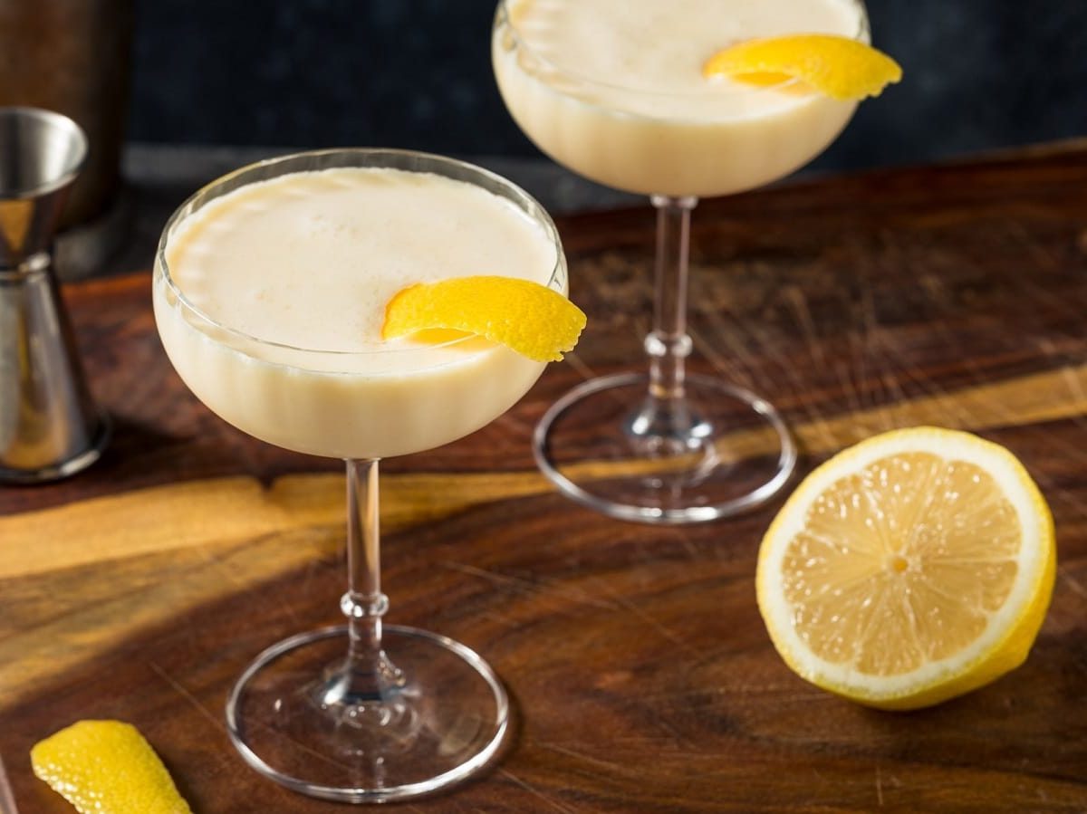 Zwei Martini-Gläser mit Canary Flip auf einem Holzbrett.