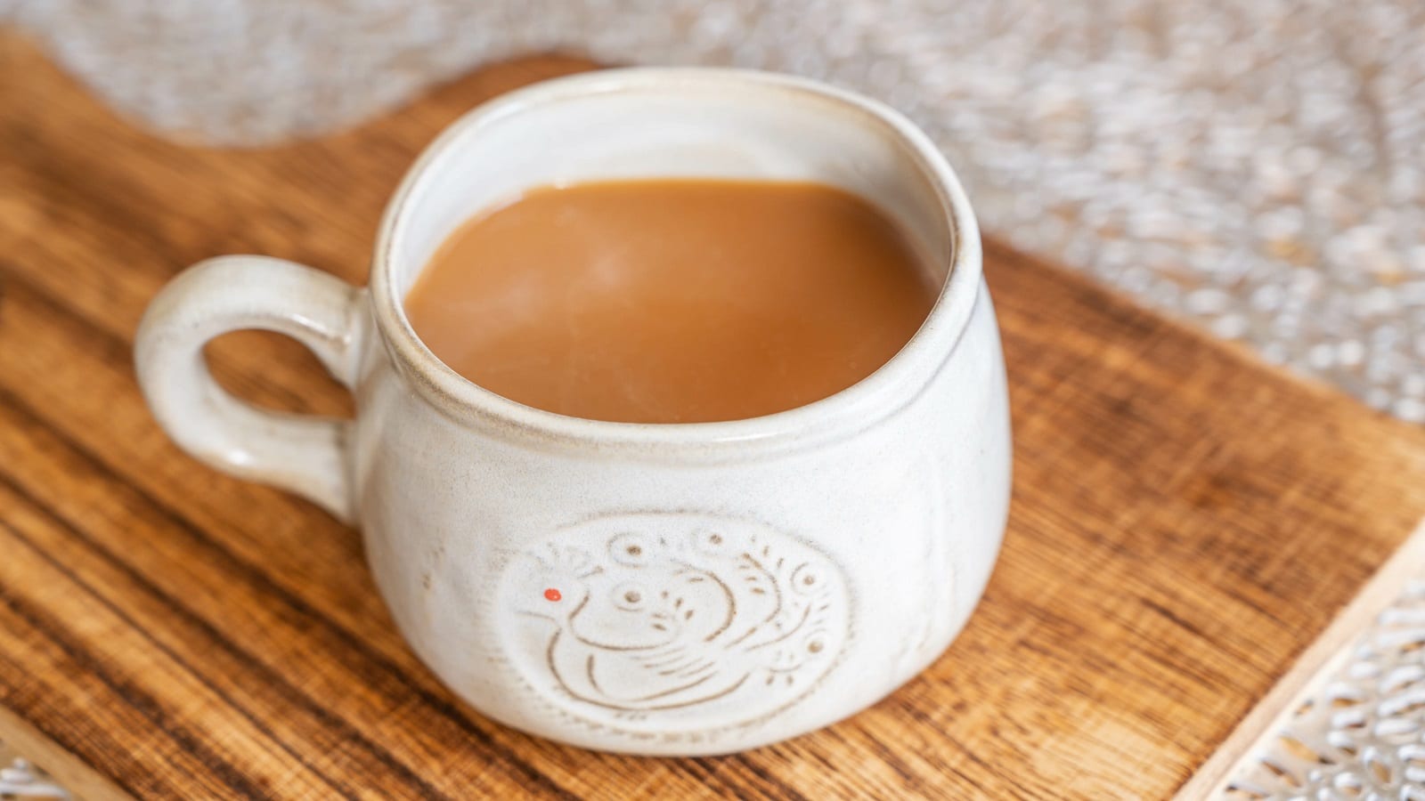 Eine Tasse mit Hong Kong Milk Tea auf einem Brett.