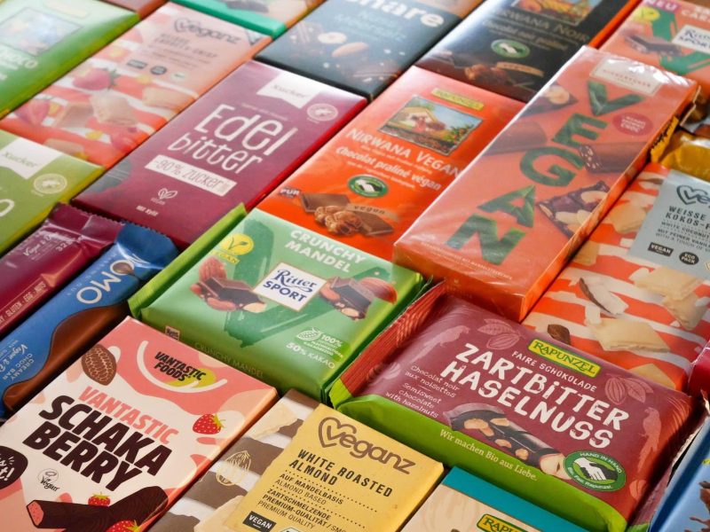 Test vegane Schokolade: viele verschiedene eingepackte vegane Schokoladen-Tafeln nebeneinander.