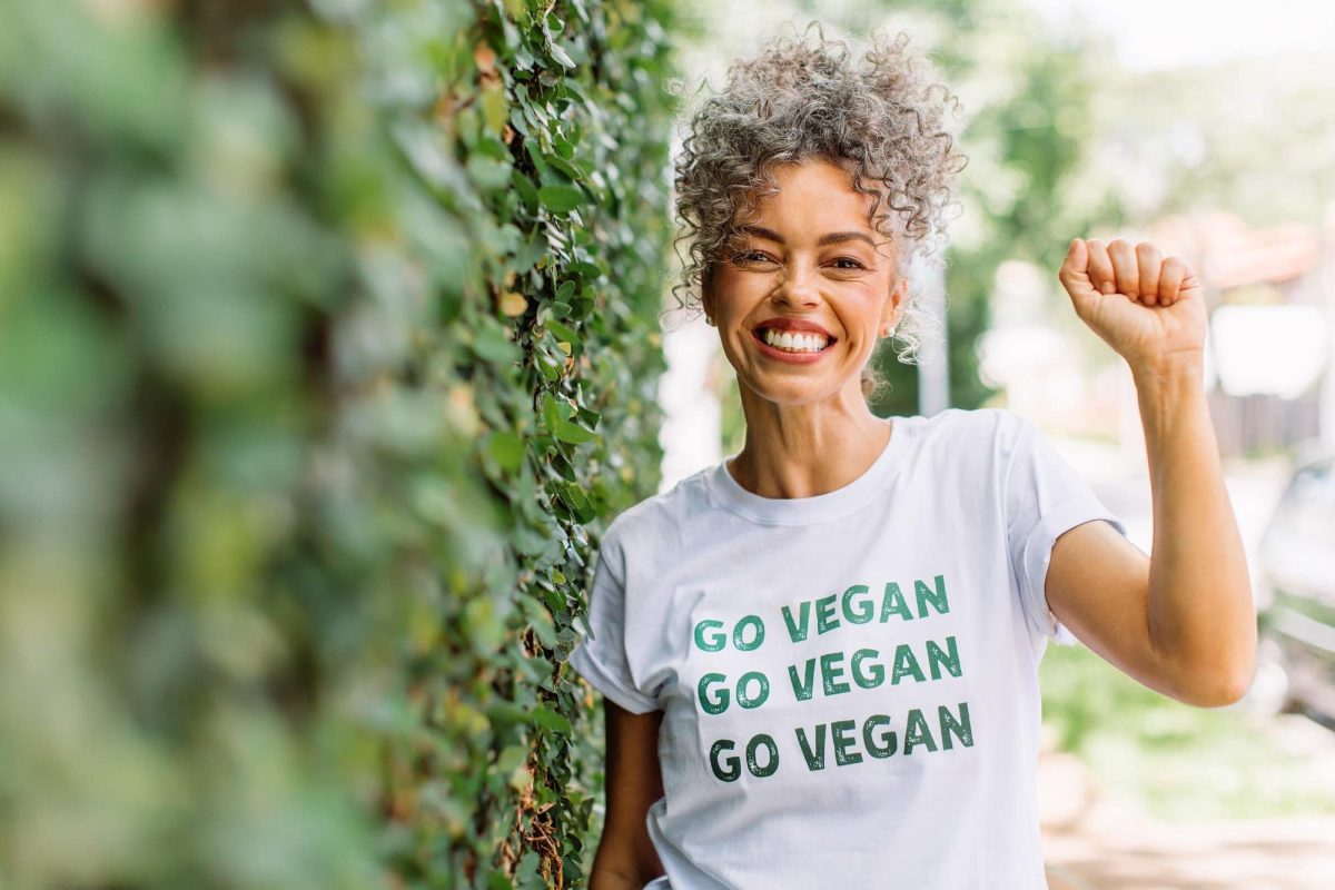 Vegan-Mythen: Eine lachende Frau trägt ein T-Shirt mit der Aufschrift "Go vegan".