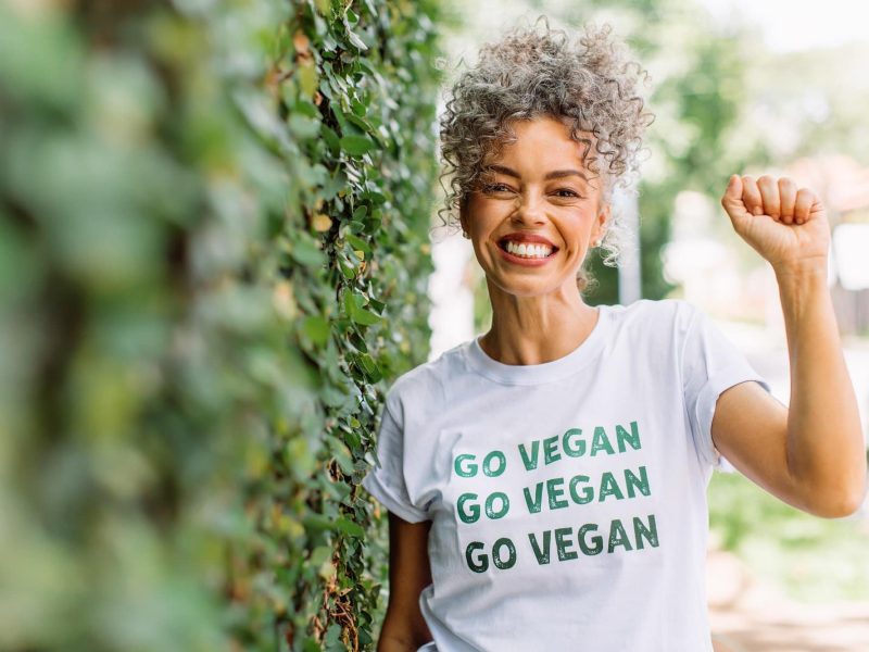 Vegan-Mythen: Eine lachende Frau trägt ein T-Shirt mit der Aufschrift "Go vegan".