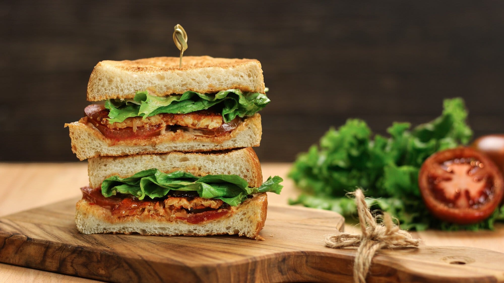 Ein veganes BLT Sandwich mit Tomaten, Salat und Bacon aus Aubergine.