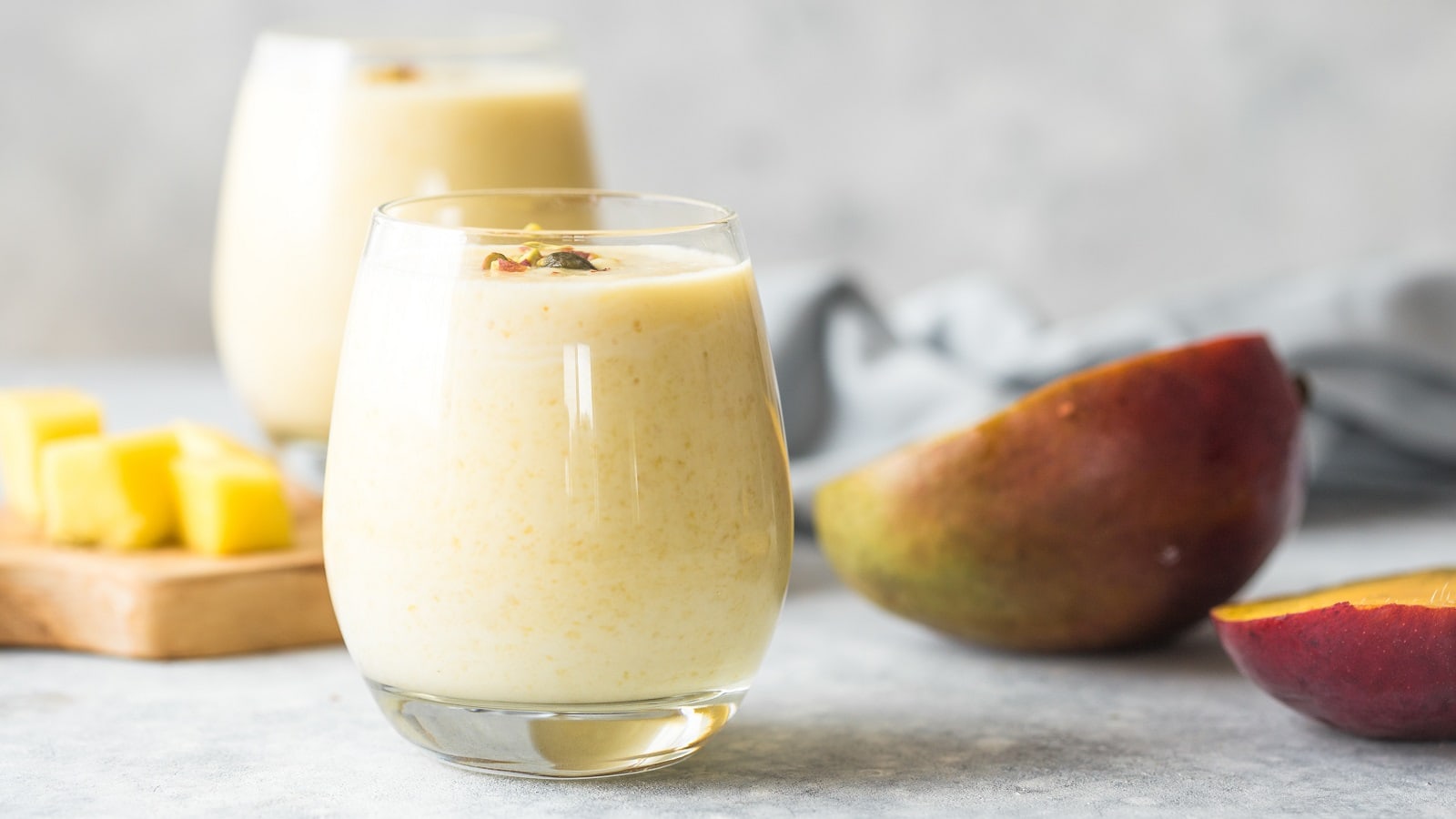 Ein Glas mit einem Kokos-Mango-Smoothie.
