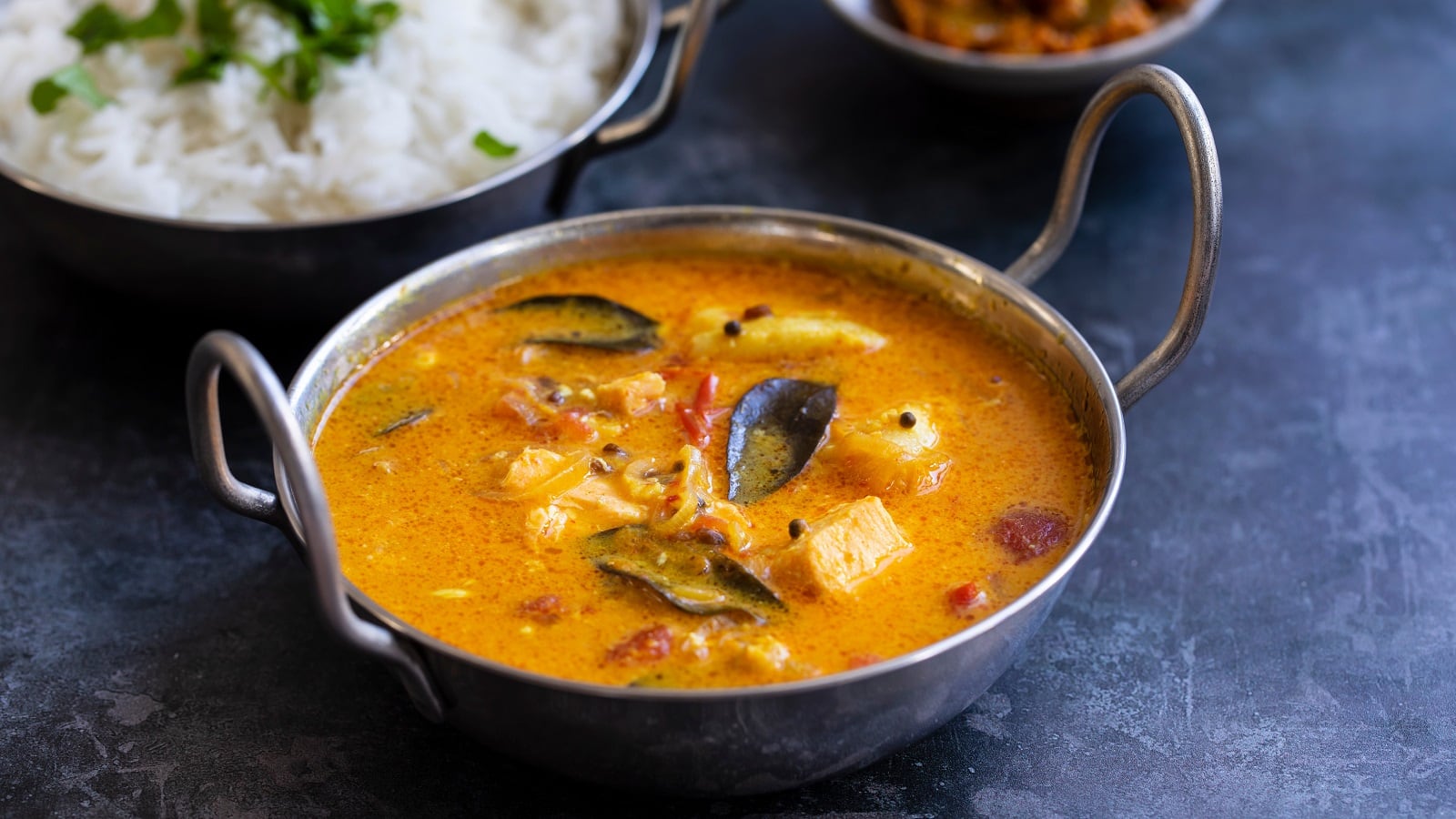 Eine kleine Metallschüssel mit Tamarinden-Curry mit Fisch.