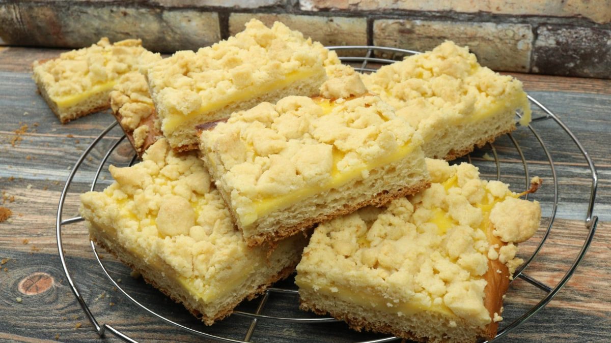 Pudding-Streuselkuchenin Stücken auf Kuchengitter und hellem Untergrund. Draufsicht