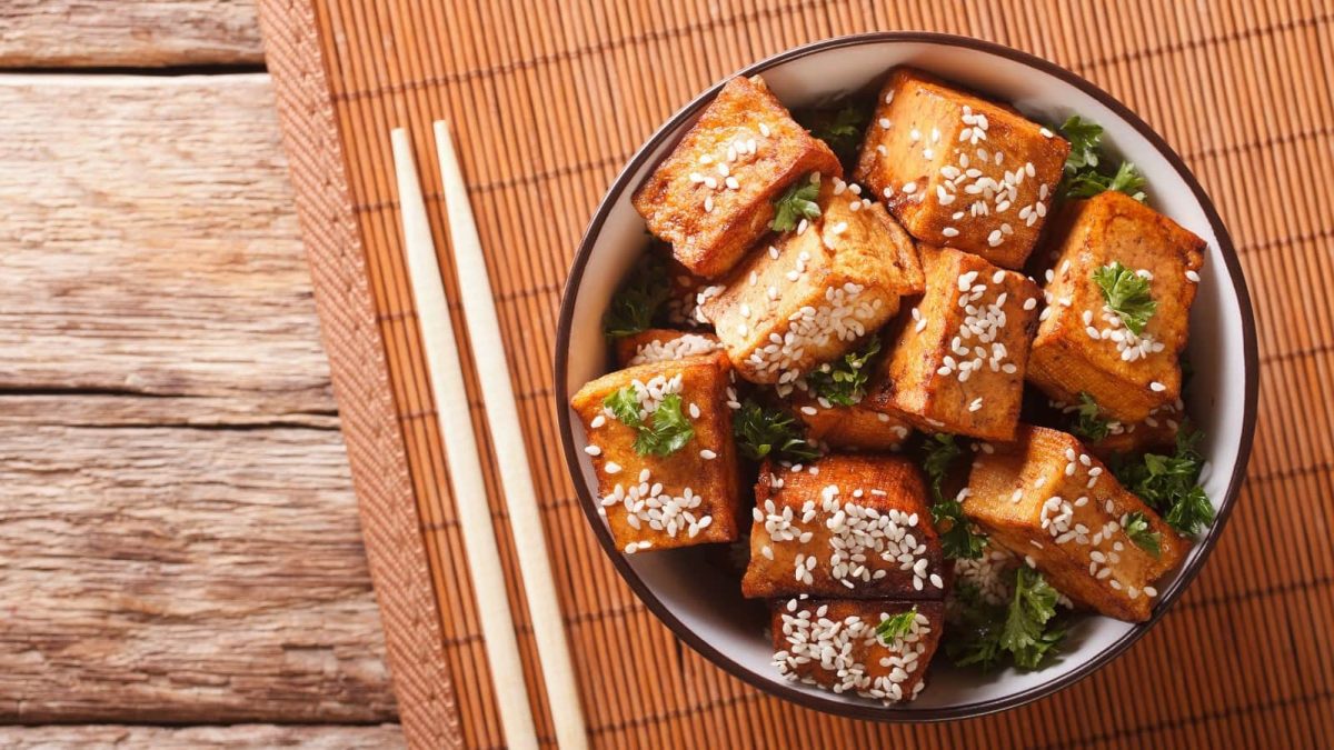 Eine runde Schüssel mit Miso-Tofu mit Chili auf einer Bambusmatte.