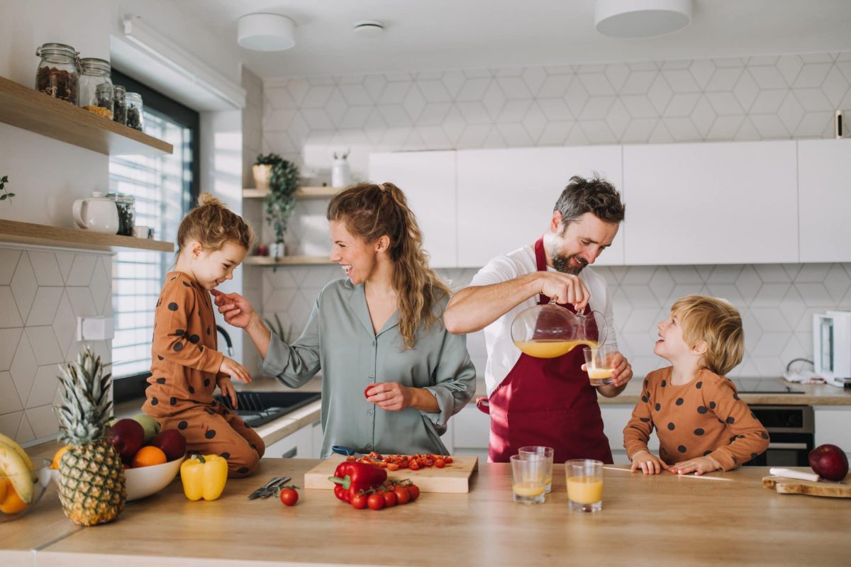 Zum Internationalen Tag der Familie Rezepte für die ganze Familie eine Familie in der Küche beim Zubereiten von Speisen. Frontalansicht.