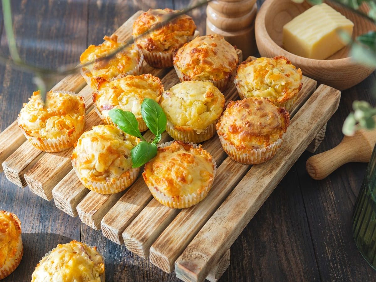 Ein Holzbrett mit Kartoffel-Muffins mit Käse.