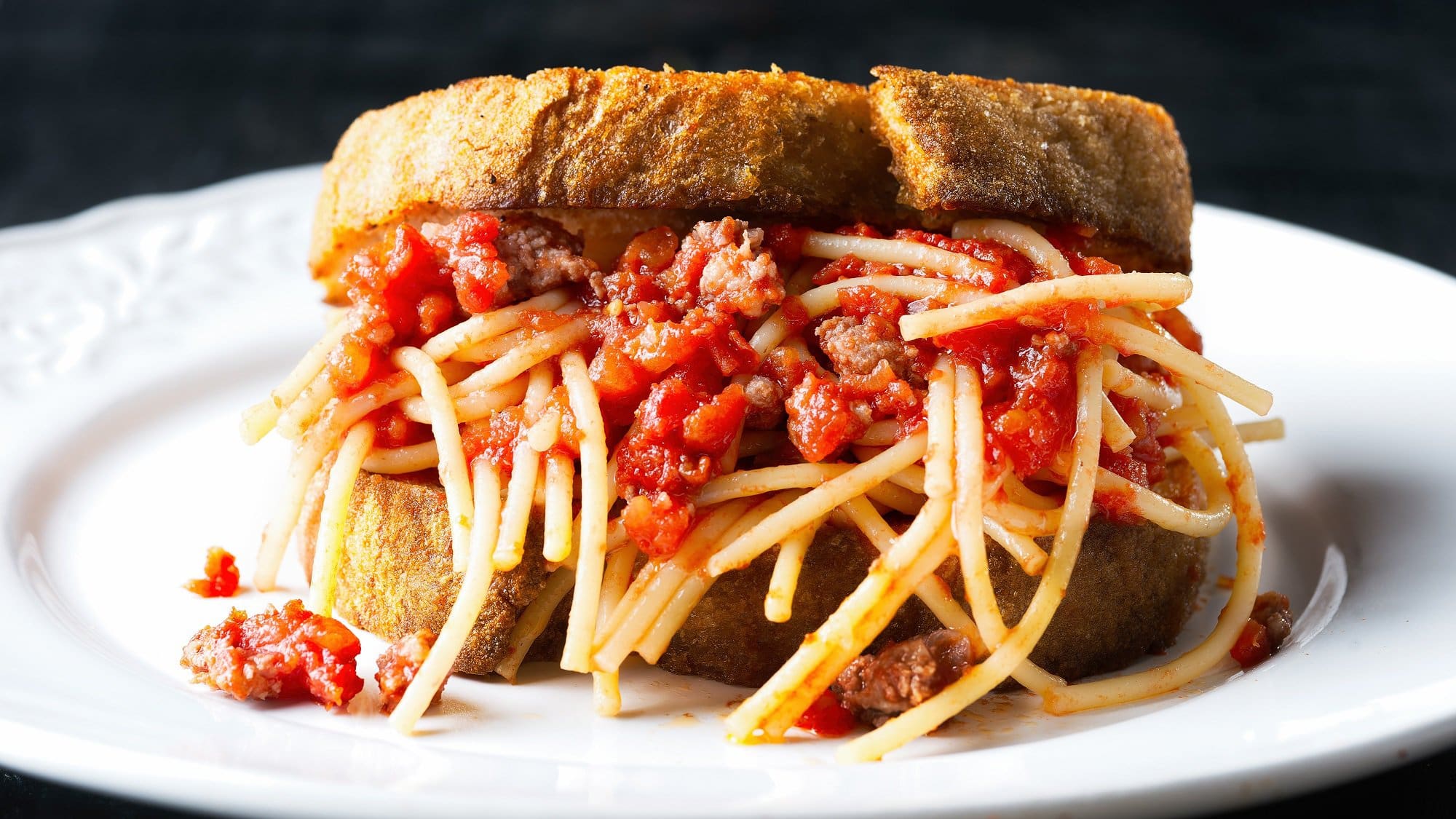Ein Teller mit einem Spaghetti-Bolognese-Sandwich.