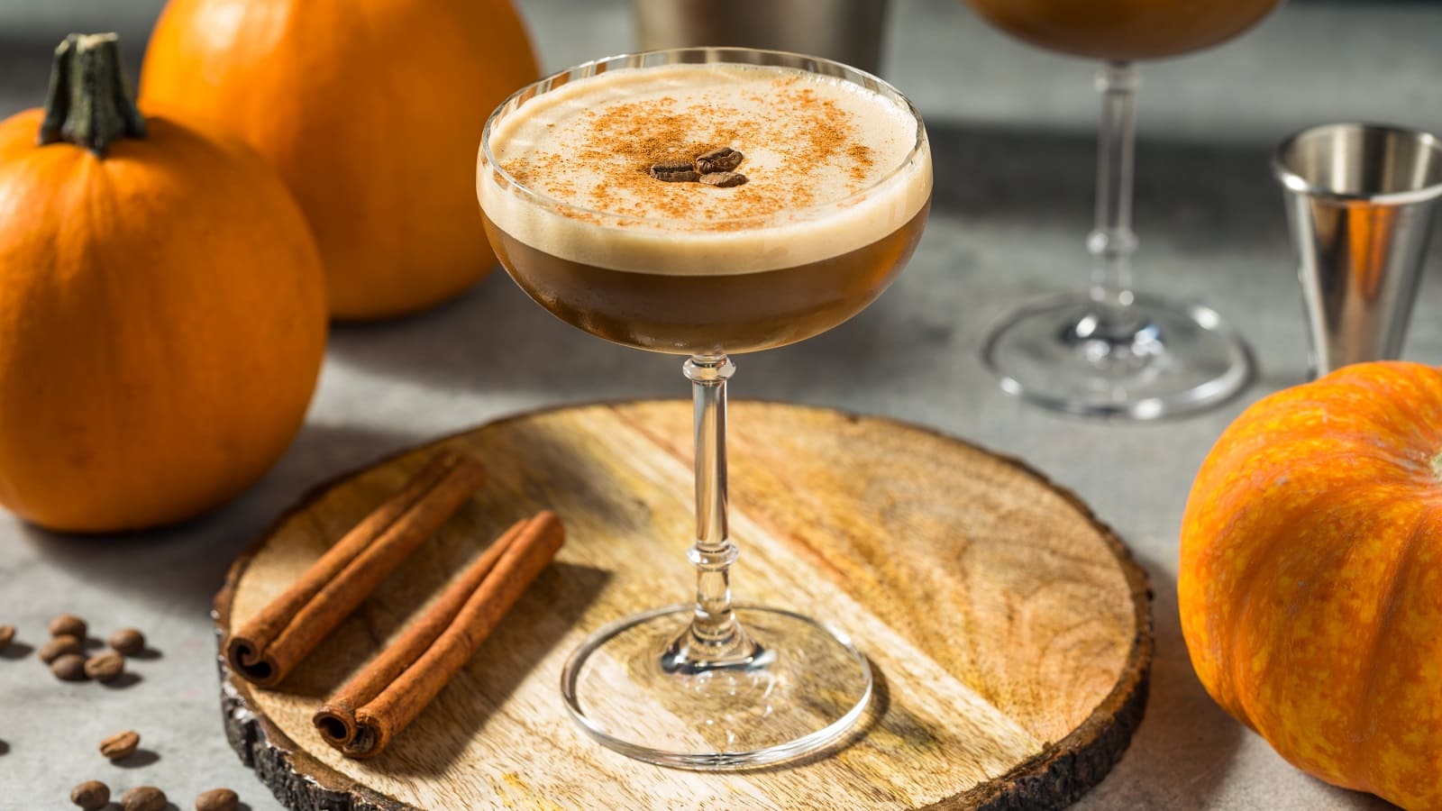 Ein Glas Pumpkin Spice Espresso Martini auf einer runden Baumscheibe.
