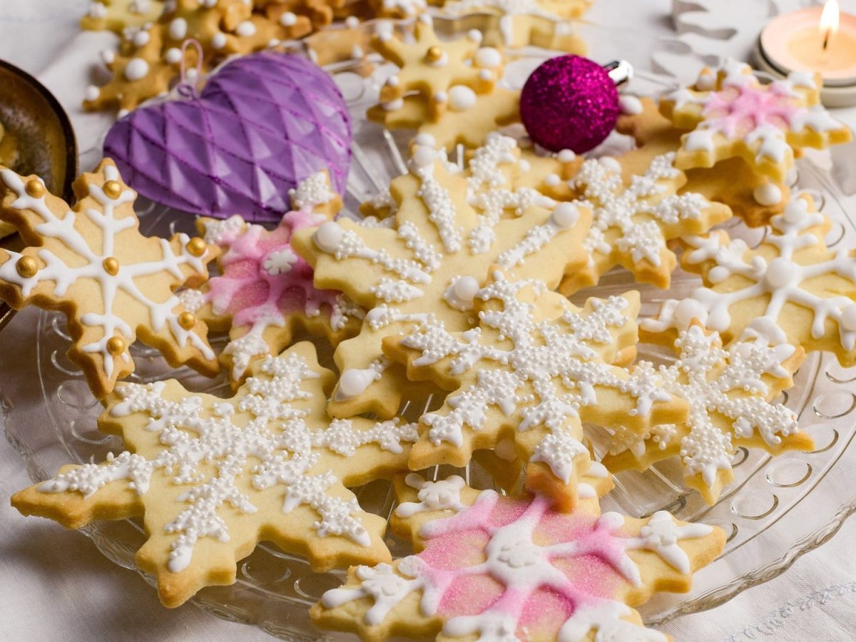 Hausgemachte Eierlikör-Plätzchen auf einem festlichen Teller. Die Plätzchen sind liebevoll mit Glasur und Zuckerperlen dekoriert.