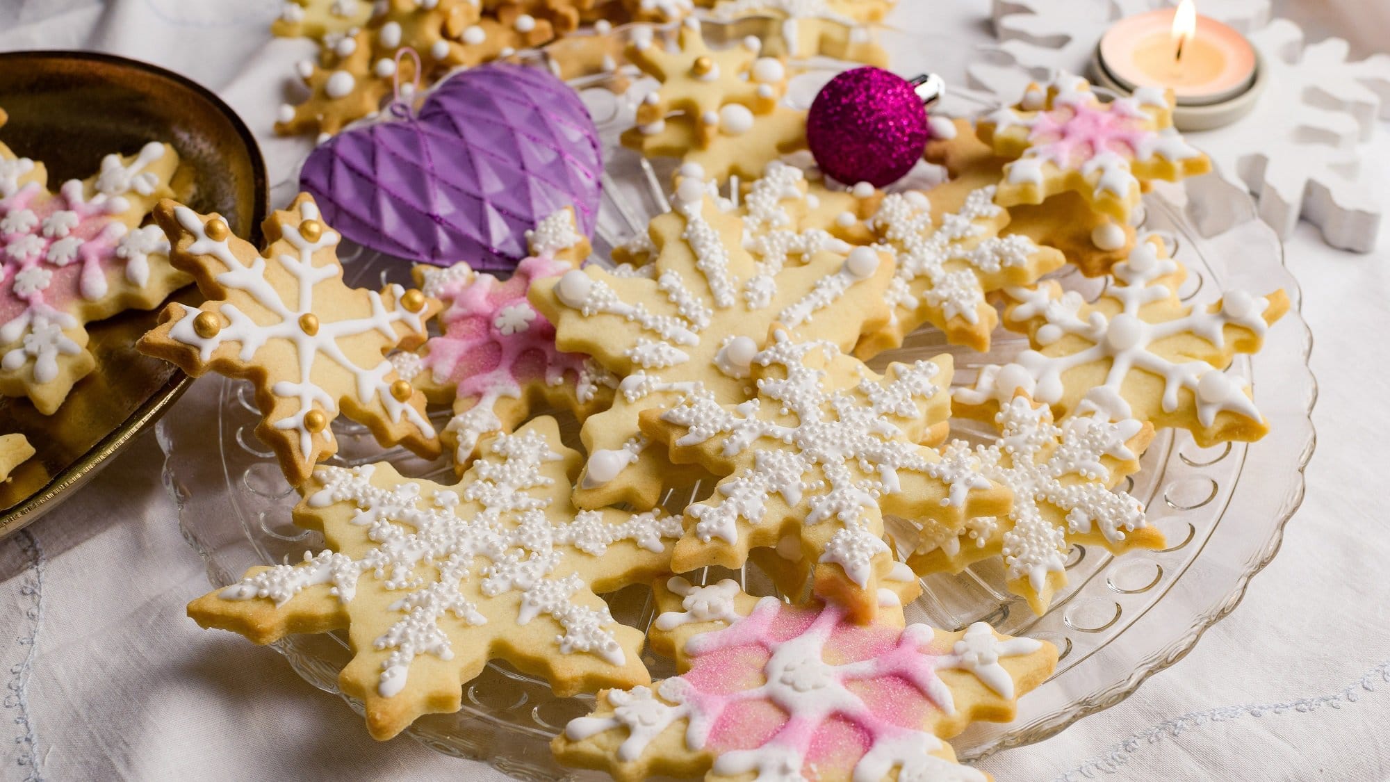 Hausgemachte Eierlikör-Plätzchen auf einem festlichen Teller. Die Plätzchen sind liebevoll mit Glasur und Zuckerperlen dekoriert.