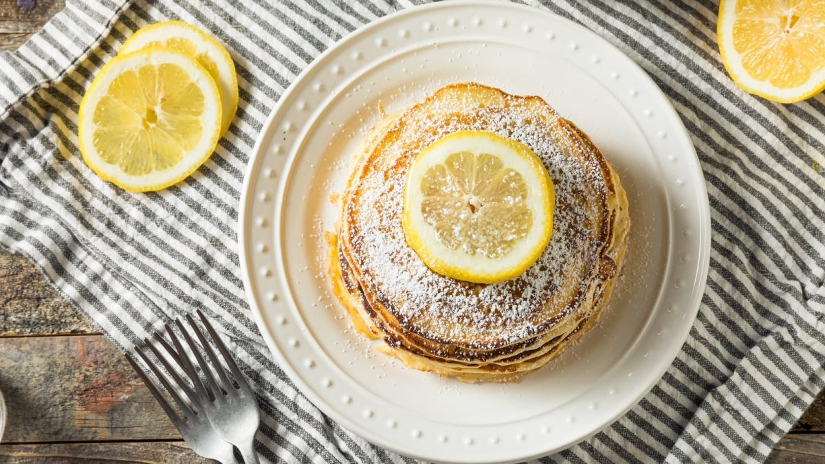 Ricotta-Zitronen-Pancakes auf einem gestreiften Tuch.