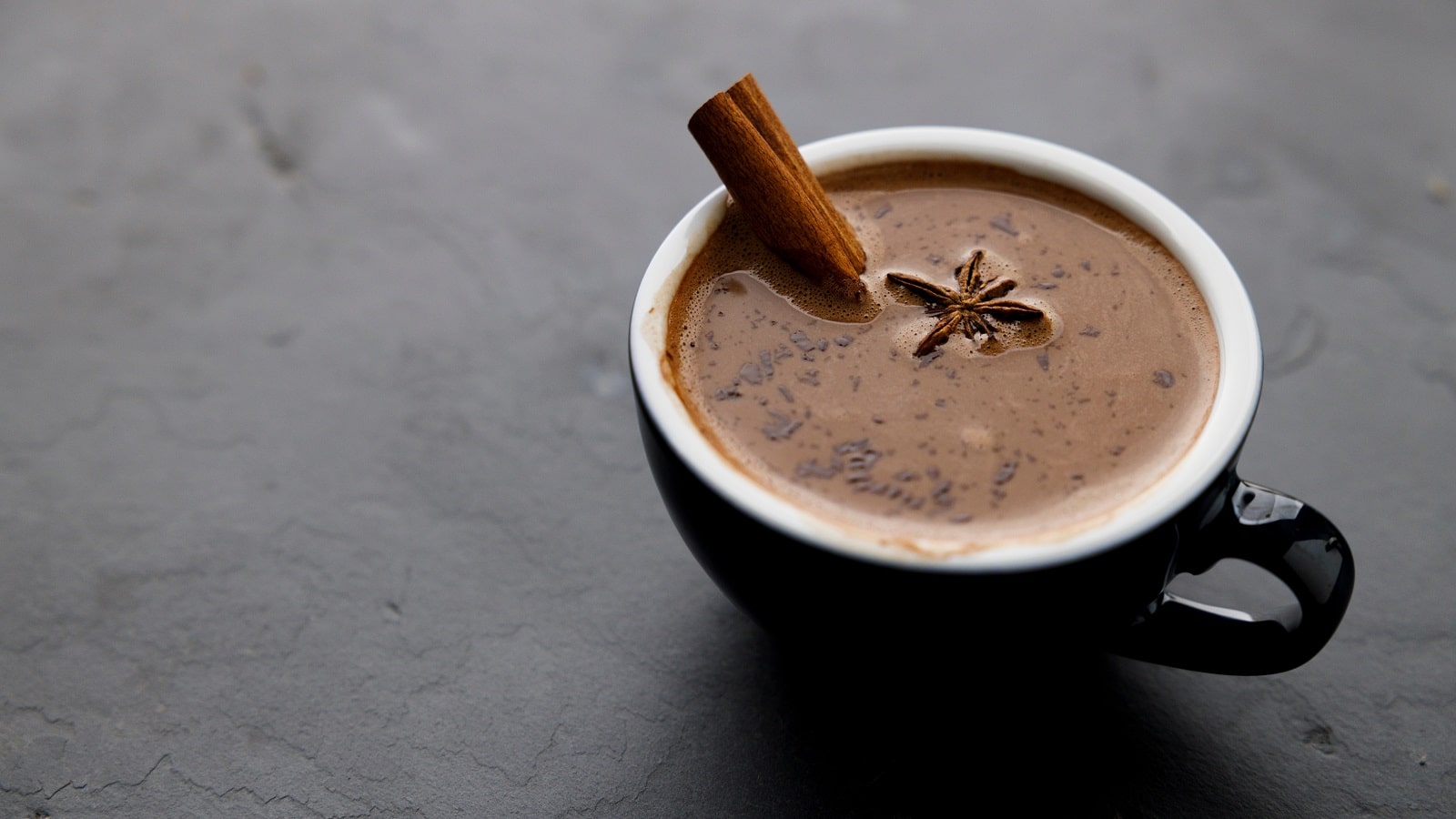 Eine Tasse heiße Chai-Schokolade auf einem grauen Tisch.