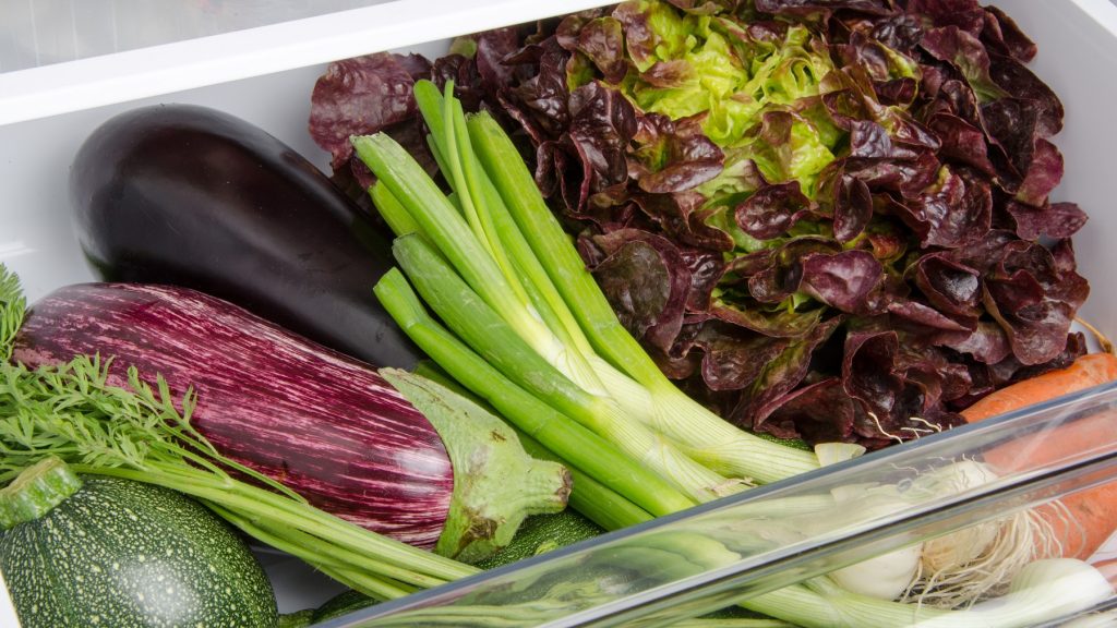 Aubergine in einem Fach im Kühlschrank zusammen mit anderem Gemüse.